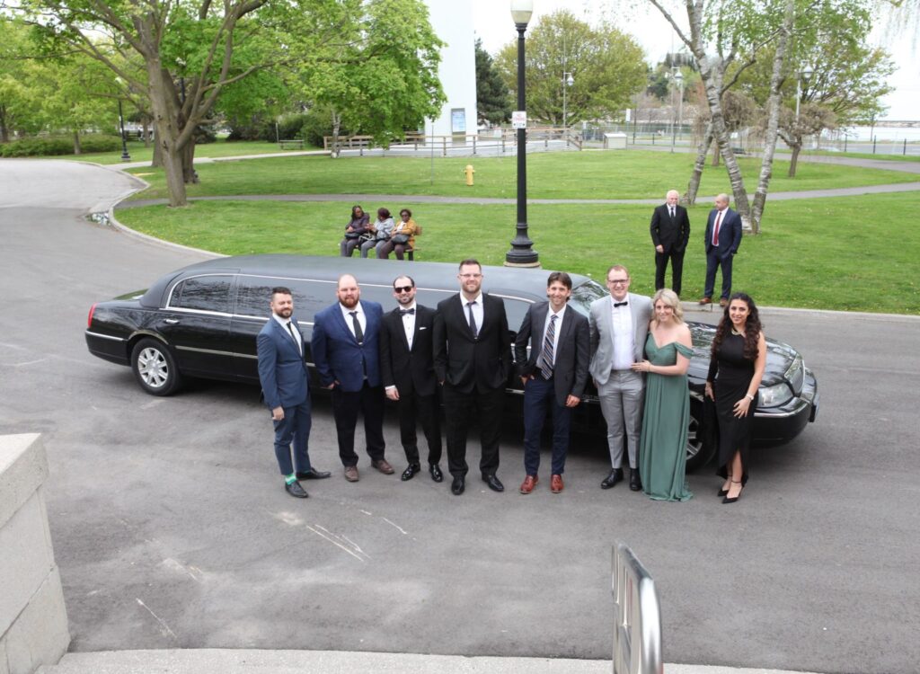 Team standing outside limousine